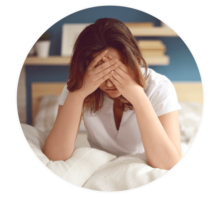 Frau mit Schlafstörungen sitzt im Bett 